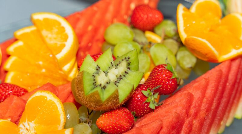 Fresh tropical fruits including watermelon, oranges, and kiwi arranged beautifully.